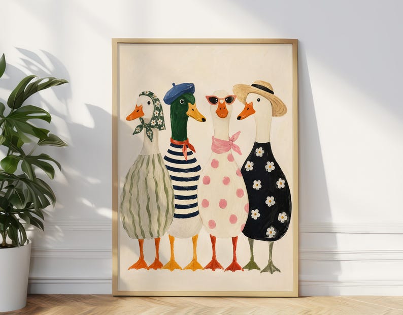 May include: A framed art print featuring four anthropomorphic ducks. Each duck is dressed in unique attire, including dresses, hats, and scarves. The ducks have orange beaks and feet, with a neutral background. The artwork is displayed against a white wall and a wooden floor.