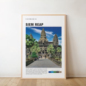 Pode incluir: Um poster emoldurado com uma fotografia do templo de Angkor Wat em Siem Reap, Camboja. O poster tem o texto "CAMBODIA" e "SIEM REAP" no topo. A imagem mostra o templo com um céu azul e árvores verdes. O poster está numa moldura castanha clara.