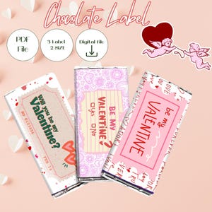 May include: Valentine's Day chocolate labels with various designs. One label reads "Will you be my Valentine?" with a heart and the date. Another says "Be my Valentine?" with "Yes" and "No" options. The third label says "Be my Valentine".
