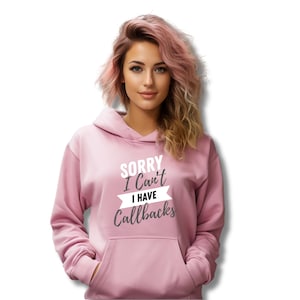 May include: A pink hoodie with the text "SORRY I Can't I HAVE Callbacks" in white and grey lettering.
