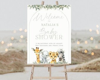 Puede incluir: Un cartel de bienvenida a la Baby Shower de Natalia con un borde de hojas verdes y un arco. El cartel presenta una ilustración de una jirafa, un elefante, un león y una cebra. El texto dice "Bienvenido a la Baby Shower de Natalia 3 PM Sábado 16 de agosto Dos mil veinticuatro".