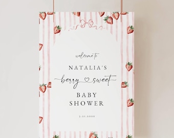 May include: A rectangular baby shower sign featuring a white center with the text "welcome to NATALIA'S berry sweet BABY SHOWER 3.21.20XX". The border has vertical light pink stripes and watercolor strawberry illustrations with a pink bow.