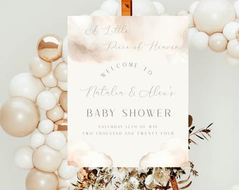 May include: A white and beige watercolor baby shower sign with the text "A Little Piece of Heaven" and "Welcome to Natalia & Alex's Baby Shower" with the date "Saturday 12th of May Two Thousand and Twenty Four".