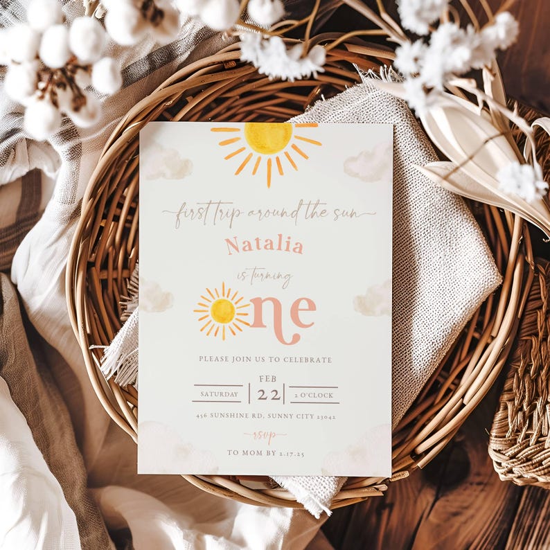 May include: A light blue invitation with a yellow sun and clouds. The text reads "first trip around the sun Natalia is turning one" with a pink number one. The invitation also includes details for a party on 22nd February at 1 o'clock.