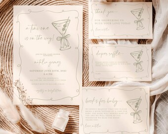May include: A set of baby shower invitations and cards in a neutral color palette. The main invitation reads "a tiny one is on the way!" with event details. Additional cards include "thank you," "diaper raffle," and "books for baby."