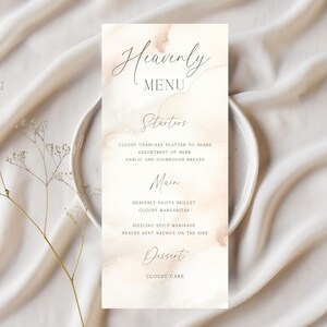 May include: A rectangular menu card with the title "Heavenly Menu" in elegant script. The menu features sections for starters, main courses, and dessert, with dishes like "Cloudy Crabcake Platter" and "Cloudy Cake". The card has a soft, watercolor-like background.