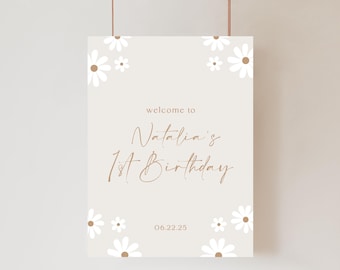 May include: A beige welcome sign with daisy accents. The sign reads "welcome to Natalia's 1st Birthday" in a stylish script font. The date "06.22.25" is displayed at the bottom. White daisies with brown centers are placed in the corners and around the text.