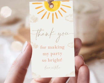 May include: A white thank you tag with a watercolor illustration of a yellow sun with orange rays and white clouds. The text reads "Thank you for making my party so bright! Love, Natalie."