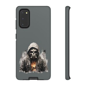 Könnte beinhalten: Graue Handyhülle mit einem Kapuzenmann mit Totenkopfmaske und Atemschutzmaske. Das Kunstwerk ist im Aquarellstil gehalten und hat ein dunkles, urbanes Thema. Die Hülle hat ein schwarzes Kameramodul und Seitentasten.