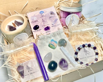 May include: A purple and white crystal gift box with a variety of crystals, a candle, and a bracelet. The box is filled with wood shavings and has a label that says "Mooliit Perception".