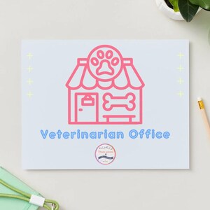 May include: A light blue card with a pink illustration of a veterinarian's office, including a paw print, bone, and door. The words "Veterinarian Office" are in blue. A pencil and other objects are in the background.