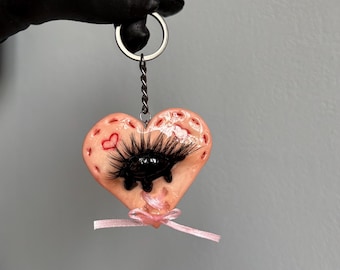 Handmade polymer clay keychain in the shape of a heart with a dark eye skin