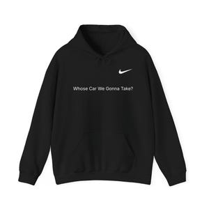 May include: Black hoodie with a front pocket and a drawstring. The Nike swoosh logo is on the upper right chest. The text "Whose Car We Gonna Take?" is printed in white across the chest.