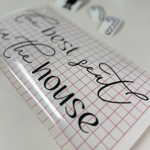 Könnte beinhalten: Ein weißes Blatt Papier mit einem roten Rastermuster. Die Worte "The best seat in the house" sind in schwarzer Kursivschrift auf das Papier geschrieben.