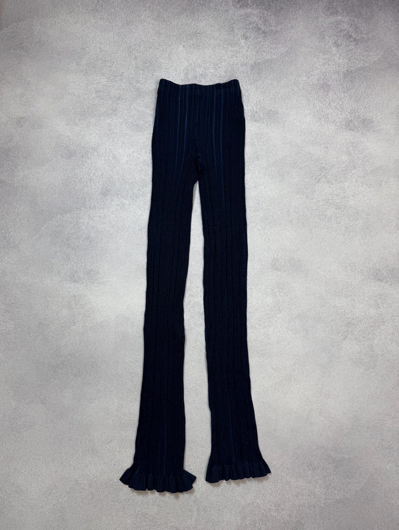 Puede incluir: Pantalones de punto acanalado azul marino con pernera acampanada y bajo con volantes. Los pantalones est&aacute;n hechos de un material suave y el&aacute;stico. Una adici&oacute;n vers&aacute;til a cualquier guardarropa, adecuada para diversas ocasiones.