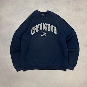 Puede incluir: Sudadera azul marino de cuello redondo con la palabra "CHEVIGNON" arqueada en el pecho en letras blancas. Debajo del nombre de la marca está el texto "1957" y "Paris France". La sudadera tiene mangas largas y cuello acanalado.