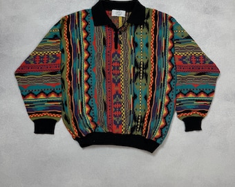 May include: A colorful vintage sweater with a collared neckline and a quarter-zip closure. The sweater features a vibrant pattern of vertical stripes in teal, red, yellow, and black. The cuffs and collar are solid black.