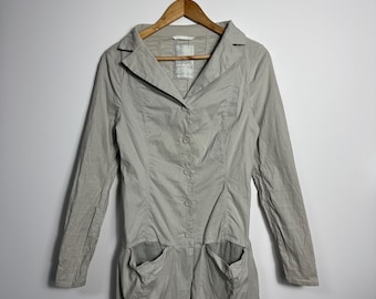 May include: A light gray long-sleeve jacket with a button-up front and two large pockets. The jacket is hanging on a wooden hanger against a white background. The jacket has a collared neckline.