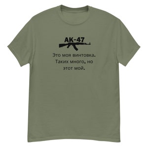 以下が含まれることがあります： AK-47の黒いグラフィックと「AK-47. Это моя винтовка. Таких много, но этот мой.」というテキストが書かれた緑色のTシャツ