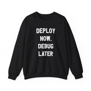 Könnte beinhalten: Ein schwarzes Langarm-Sweatshirt mit Rundhalsausschnitt und dem weißen, im Used-Look gestalteten Text "DEPLOY NOW. DEBUG LATER" mittig auf der Brust. Das Kleidungsstück hat einen gerippten Halsausschnitt, Bündchen und einen Saum.