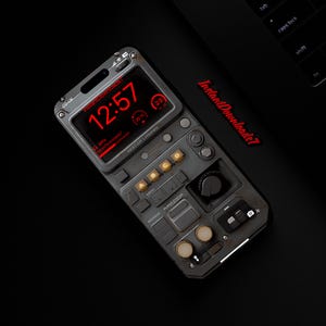 May include: A gray and black phone case with a retro-futuristic design. The screen displays the time in red, along with other data. The case has buttons and dials, and the text "InstantDownloads7" is visible.