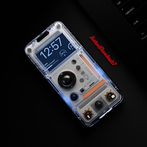 以下が含まれることがあります： 未来的なデザインの透明な携帯電話ケース。ケースは白を基調とし、黒とオレンジのアクセントが施されています。携帯電話の画面には、12:57 のデジタル時計と「Instant Downloads7」の文字が表示されています。