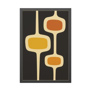 May include: Abstract mid-century modern art print. The artwork features a black background with three connected, elongated shapes in shades of yellow and orange, outlined in off-white. The print is framed in a black frame.