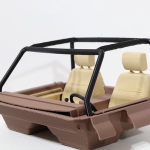 May include: A brown toy car with a black roll cage, beige seats, and a black steering wheel. The car has a detailed interior and exterior design, showcasing a miniature vehicle.