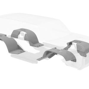 Pode incluir: Alargadores de guarda-lamas cinzentos, projetados para um veículo, são exibidos em um fundo branco. Os alargadores têm várias formas e tamanhos, com um design curvo para se ajustar às cavas das rodas. Imagem do produto.