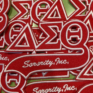 Peut inclure: Une collection d'écussons brodés rouges et blancs présentant des lettres grecques et le texte Sorority, Inc. dans une police cursive. Les écussons sont superposés, mettant en valeur la broderie rouge vif avec des bordures blanches.