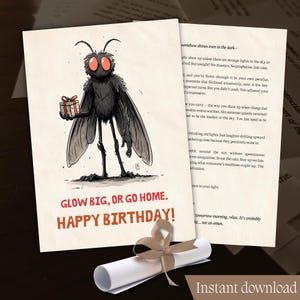 Op de afbeelding: Verjaardagskaart met een cartoonvlieg die een cadeau vasthoudt, met de tekst "GLOW BIG, OR GO HOME. HAPPY BIRTHDAY!". Een opgerolde rol met een lint is ook aanwezig.