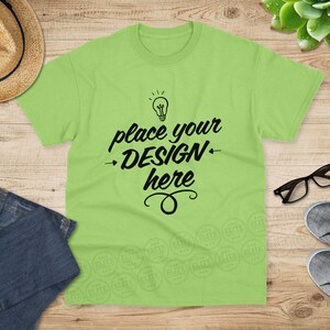 May include: A light green t-shirt with a light bulb graphic and the text "place your design here".