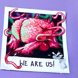 May include: A pink and green brain-like creature with tentacles, surrounded by a dark background. The image has a white border and the text "WE ARE US!" at the bottom.