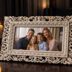 May include: A rectangular picture frame with an ornate, cream-colored border featuring intricate floral and scrollwork carvings. The frame holds a photograph of a family of four, including two adults and two children, all smiling at the camera.