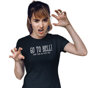 May include: A dark navy t-shirt with the white text "GO TO HELL! [AND TAKE ME WITH YOU]". The person in the image is making a fierce face and clawing with their hands.