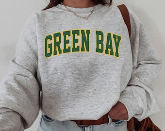 May include: Gray sweatshirt with the text "GREEN BAY" in green and yellow letters.