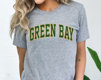 May include: A gray t-shirt with the text "GREEN BAY" in green and yellow letters.