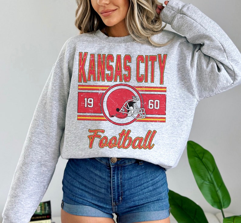 May include: A gray sweatshirt with a vintage-style graphic of a football helmet and the text "Kansas City Football" with the numbers 19 and 60.