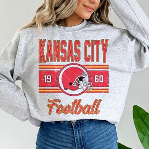 May include: Gray sweatshirt with a vintage-style graphic of a football helmet and the text "Kansas City Football" with the numbers 19 and 60.