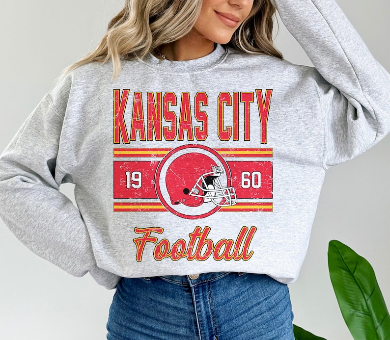 May include: Gray sweatshirt with a vintage-style graphic of a football helmet and the text "Kansas City Football" with the numbers 19 and 60.