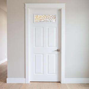 May include: A white interior door featuring four rectangular recessed panels and a single horizontal glass window at the top with a textured, grid-like pattern. The door is framed by white trim and includes a brushed metal lever handle on the right.