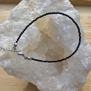 Svart turmalinarmband i fasetterade 2 eller 3 mm pärlor med spänne och liten förlängningskedja.