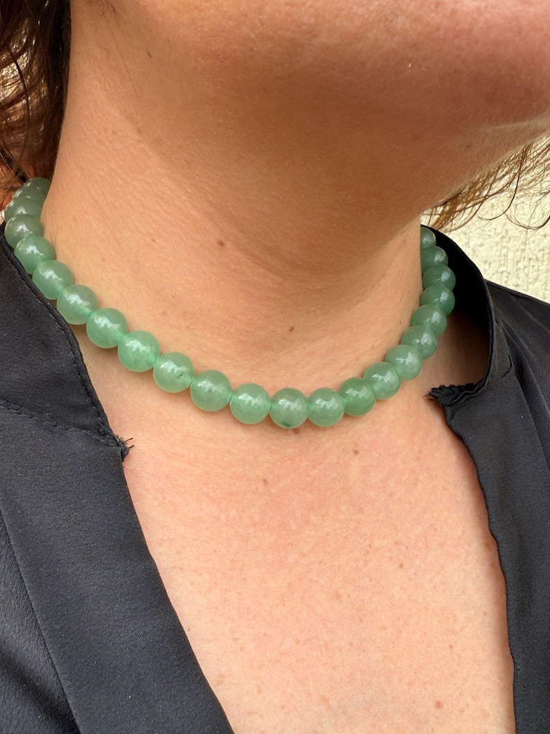 May include: A green gemstone necklace with round beads. The necklace is made of natural stones and is a beautiful piece of jewelry.