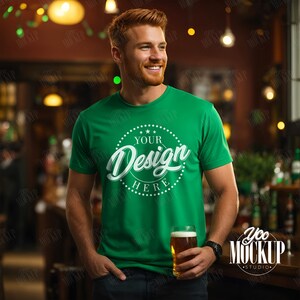 May include: A man wearing a green t-shirt with a white circle design that says "YOUR Design HERE" in a cursive font. He is holding a glass of beer in his right hand.