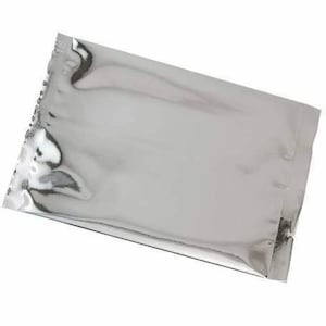 May include: A silver, rectangular, metallic pouch with a reflective surface. The pouch is sealed on three sides and has a textured, crimped edge on the top. The material appears to be a thin, flexible foil.