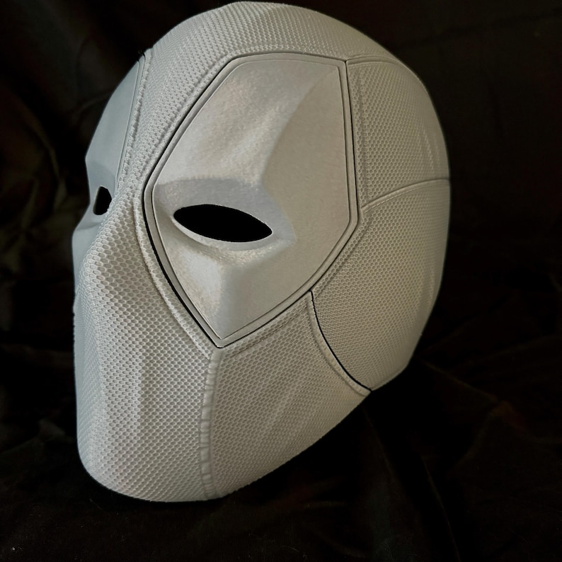 May include: A white 3D printed Deadpool mask with a textured surface and a black eye hole.
