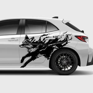 May include: A white car with a black fox graphic decal on the side. The fox is running and has a stylized, abstract design.