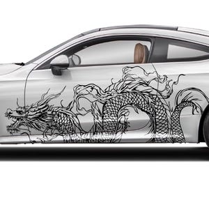 Puede incluir: Coupé blanco con un diseño de dragón negro en el lateral. El coche tiene ruedas negras e interior marrón. El diseño del dragón es detallado y cubre una gran parte del lateral del coche.