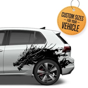 May include: A white car with a black dragon decal on the side. The decal is a silhouette of a dragon with its wings spread out. The car is a hatchback with a black grill and black wheels. The text "CUSTOM SIZES - FOR YOUR VEHICLE" is on a yellow circle sticker.