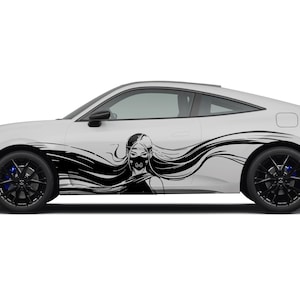 Könnte beinhalten: Ein weißes Sportauto mit schwarzen Rädern und einer schwarzen Grafik einer Frau mit langen Haaren und Gesichtsbedeckung. Die Grafik befindet sich an der Seite des Autos, mit fließenden Linien, die Bewegung suggerieren.
